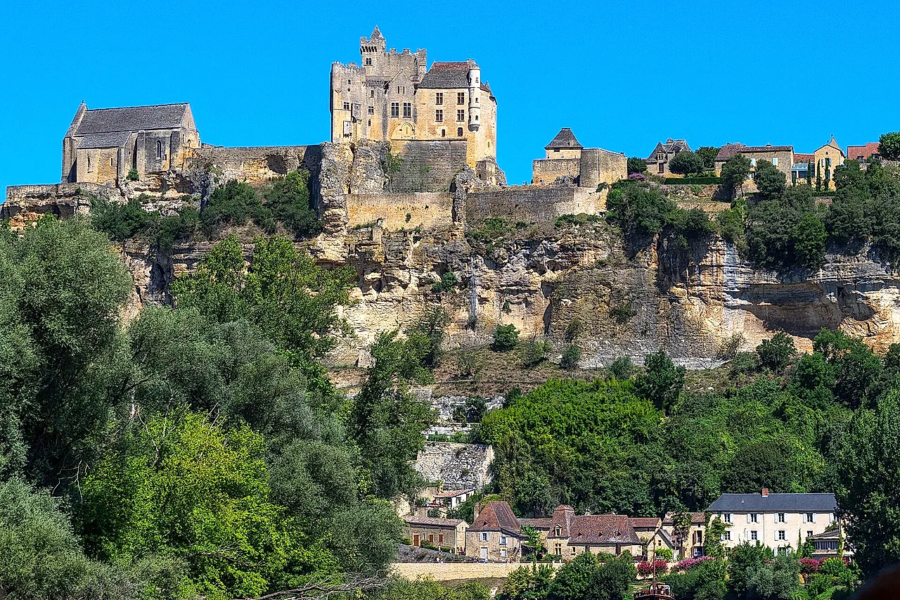 Le château de Beynac perché sur sa falaise calcaire au-dessus de la vallée de la Dordogne sous un ciel bleu profond